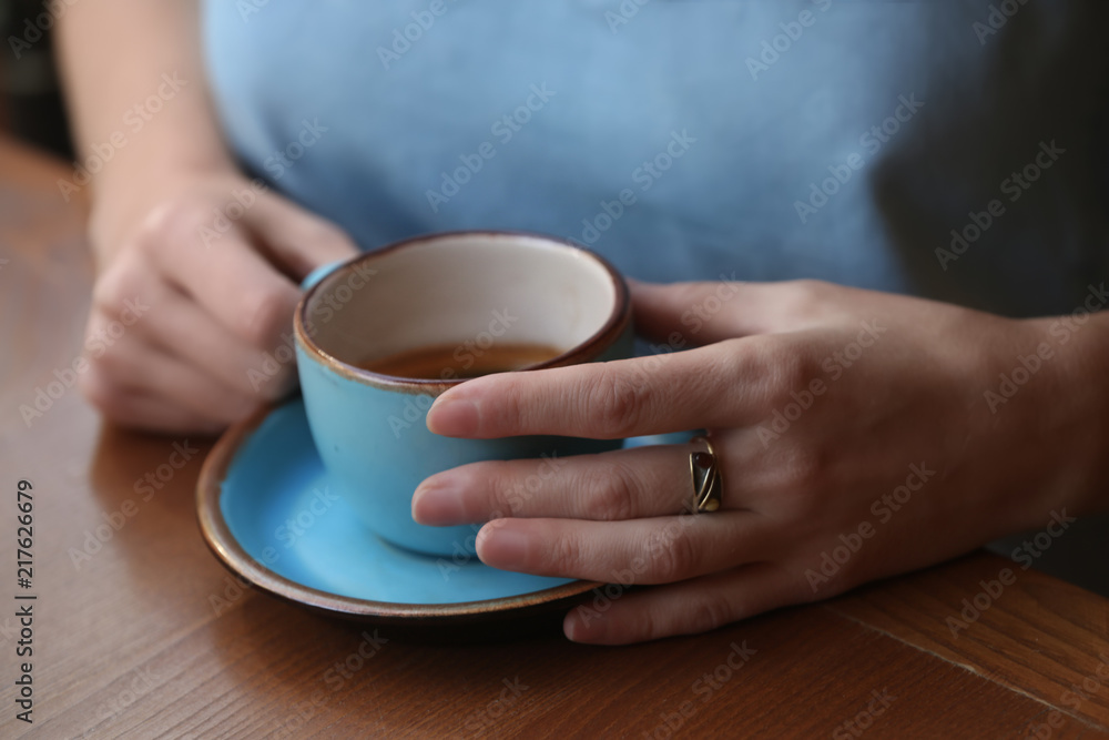 Woman with cup of fresh aromatic coffee at table, closeup Woman with cup of fresh aromatic coffee at table, closeup