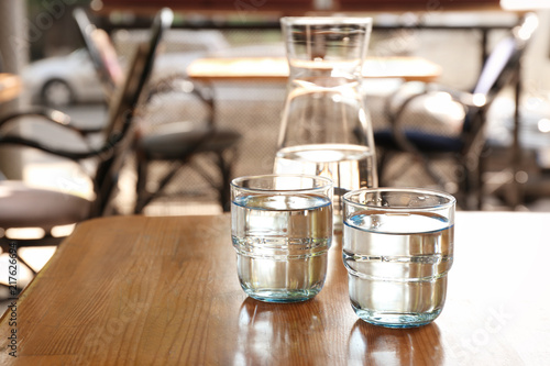 Glassware with water on wooden table indoors