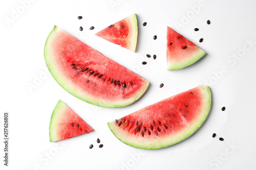 Flat lay composition with slices and seeds of watermelon on white background