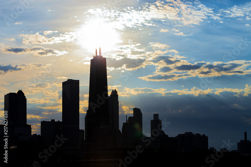 Silhouette of Chicago skyline viewed from the pier with orange and blue sunset sky in the background