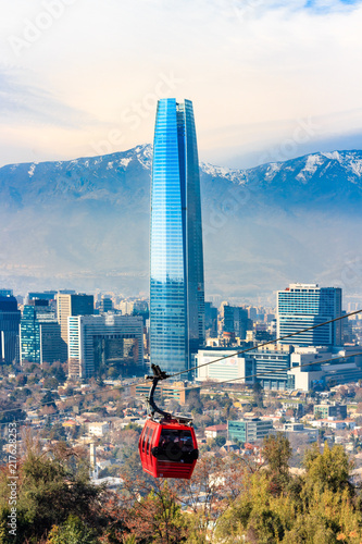 Santiago, Chile - July 14, 2018: View of the Sky Costanera Center and red cable car, with modern office buildings and the Andes Cordillera  on Cerro San Cristobal. photo