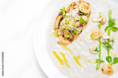 Cream mushroom soup with scallops, herbs and toast bread.