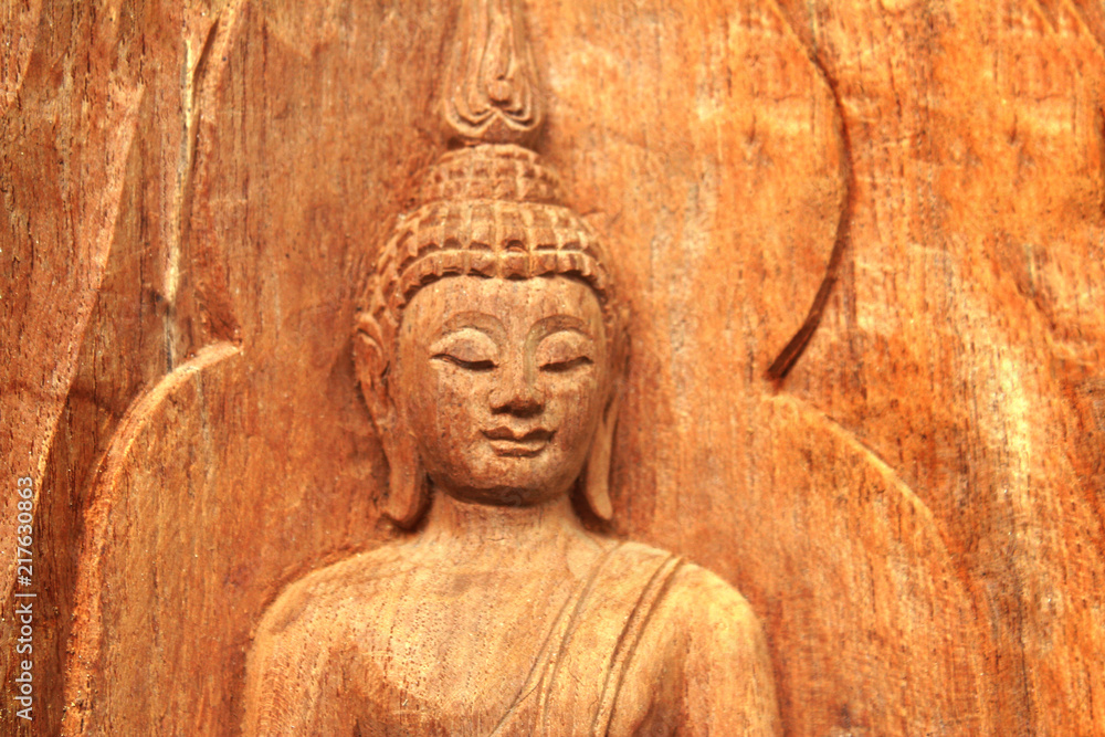 Buddha image carving on wooden brown crafts background