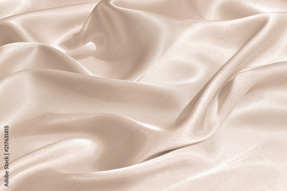 The texture of the satin fabric of beige color for the background The texture of the satin fabric of beige color for the background