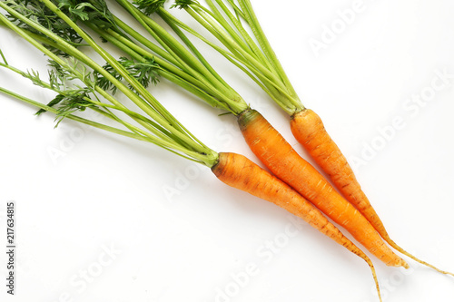 Carrots with green tops isolated on white background.