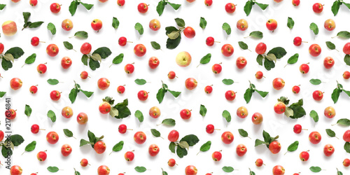 Seamless pattern of fresh red apples with green leaves isolated on a white background, top view, flat lay. Food texture.
