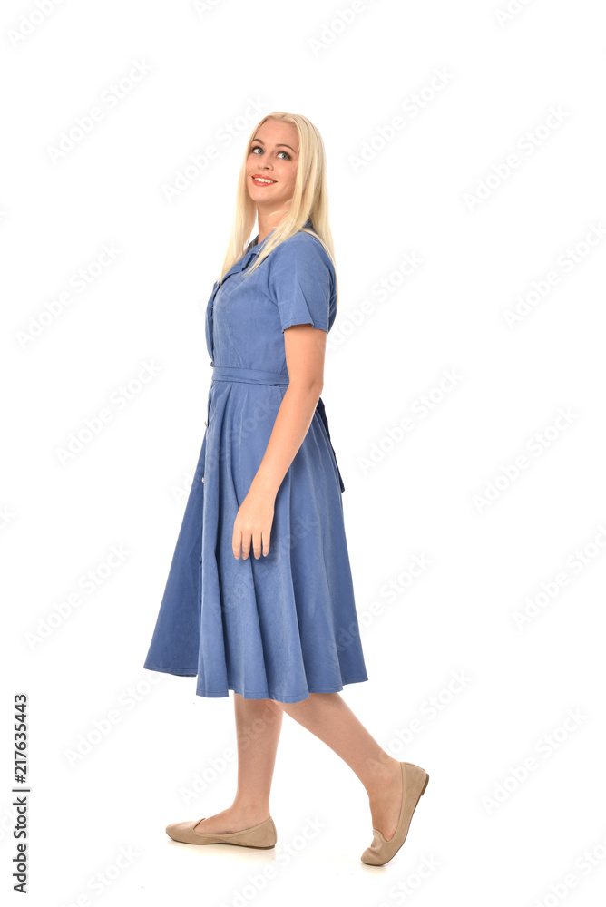 full length portrait of blonde girl wearing blue dress, standing pose. isolated on white studio background. full length portrait of blonde girl wearing blue dress, standing pose. isolated on white studio background.
