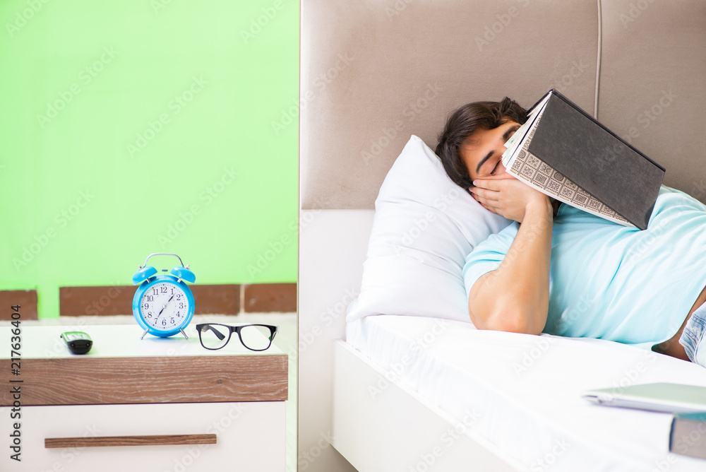 Student preparing for exams at home in bedroom lying on the bed Student preparing for exams at home in bedroom lying on the bed