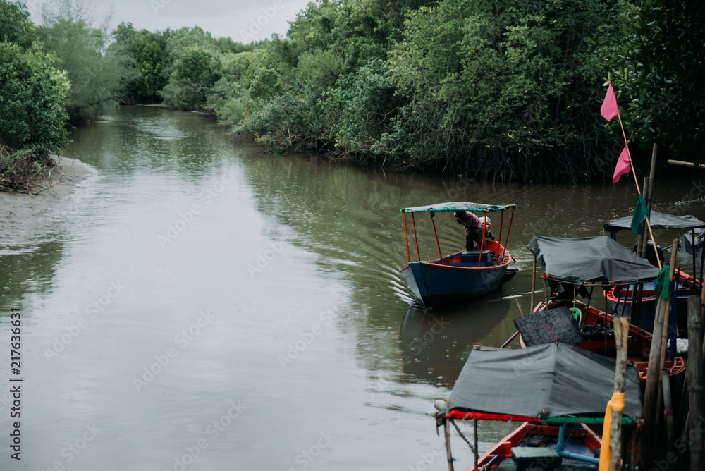 Fishing boat on a rainy day. The mangrove forests of Thailand.