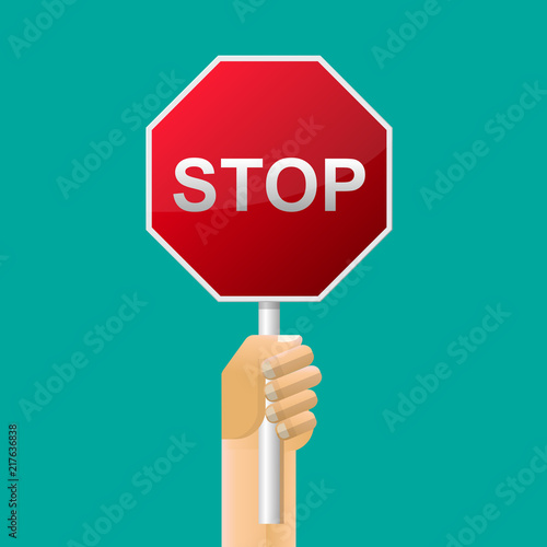 A hand holding a traffic sign stop.