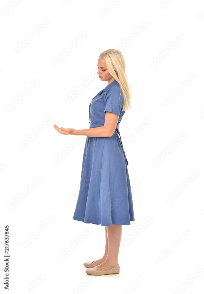 full length portrait of blonde girl wearing blue dress, standing pose. isolated on white studio background. full length portrait of blonde girl wearing blue dress, standing pose. isolated on white studio background.
