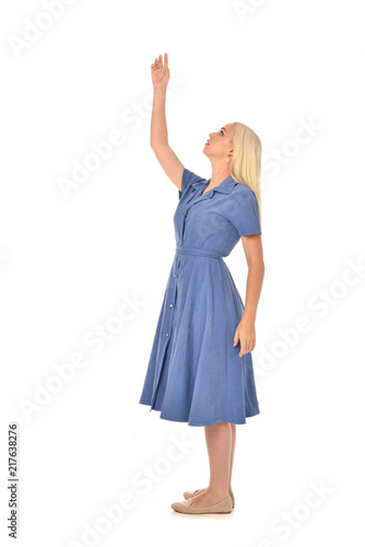 full length portrait of blonde girl wearing blue dress, standing pose. isolated on white  studio background. © faestock