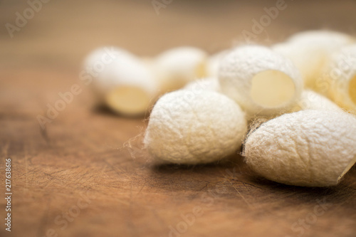 Group of white silk cocoons placed on the wooden floor,Vintage style.
