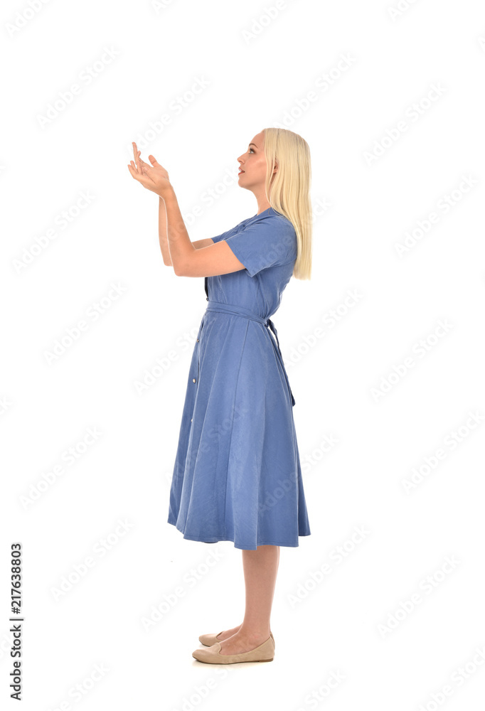full length portrait of blonde girl wearing blue dress, standing pose. isolated on white studio background. full length portrait of blonde girl wearing blue dress, standing pose. isolated on white studio background.