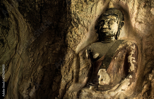 Amazing ancient Buddha statue on the wall of Thailand cave.