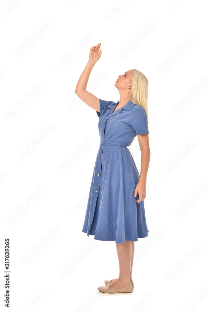 Fototapeta premium full length portrait of blonde girl wearing blue dress, standing pose. isolated on white studio background.