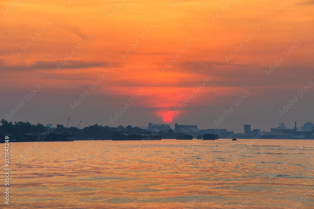Cargo ship on river at sunrise