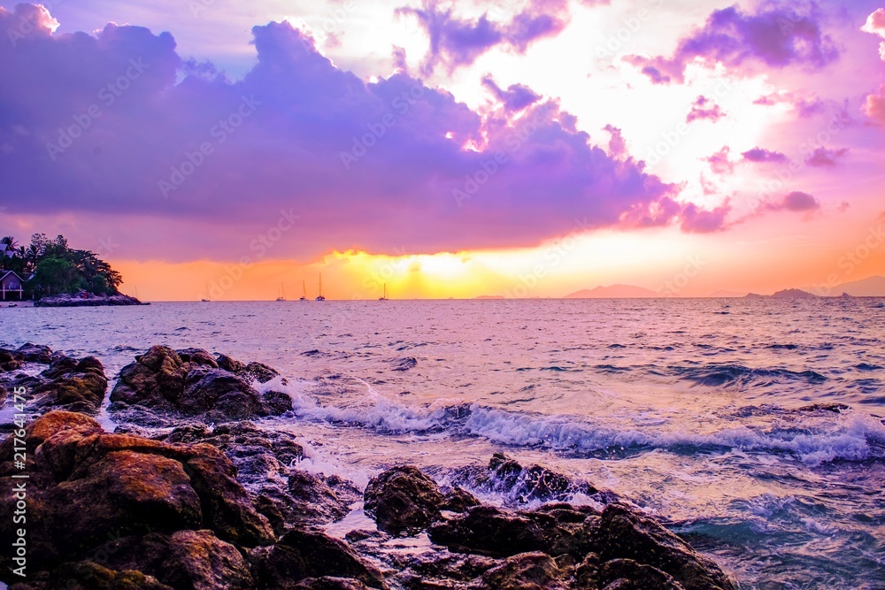 Obraz premium Beautiful scenic natural Evening scene seascape with cloud sunset Colors Over the sea Beach Rocks at lipe island Thailand,vivid and vibrant magenta color over the sea.