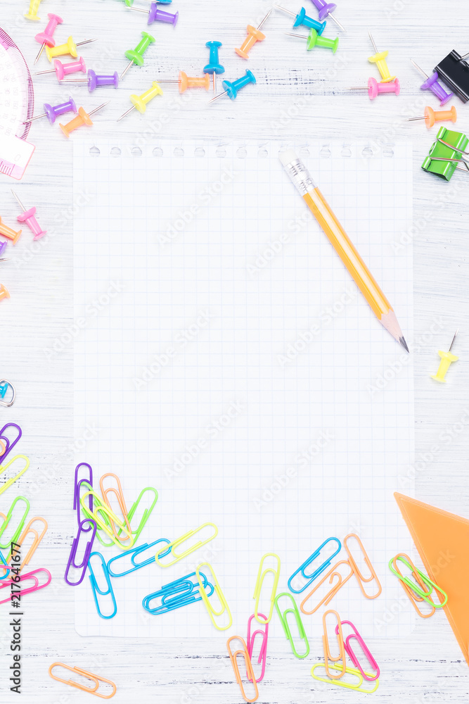 The concept of office supplies with a sheet for taking notes in the middle The concept of office supplies with a sheet for taking notes in the middle
