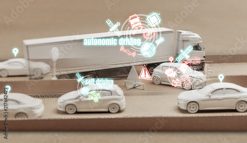 Weisser Autonomer LKW auf einer Kartonautobahn umfährt einen Verkehrspanne.