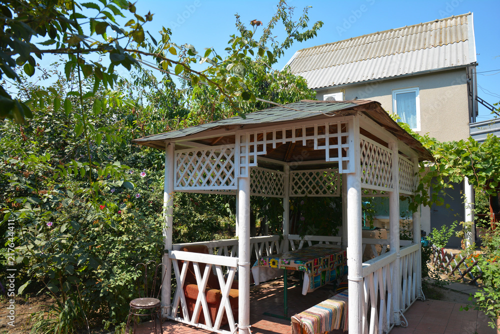 Beautiful alcove, wooden arbor, pavilion, bower, summer house, garden house in the garden.