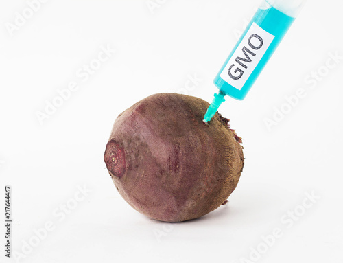 Beetroot on a white background in which is injected from the syringe gmo and nitrates, close-up, beetroot and nitrates, genetically modified organism photo