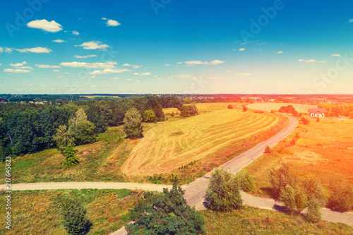 Aerial view of the countryside, beautiful round arable field, and forest. Rural landscape with the beautiful sky on a sunny day