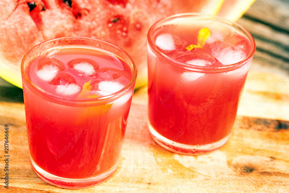 Watermelon slices and juice on wooden table Watermelon slices and juice on wooden table
