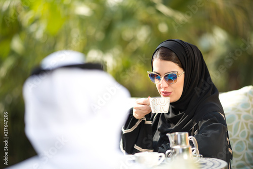 Arab woman drinking coffee.