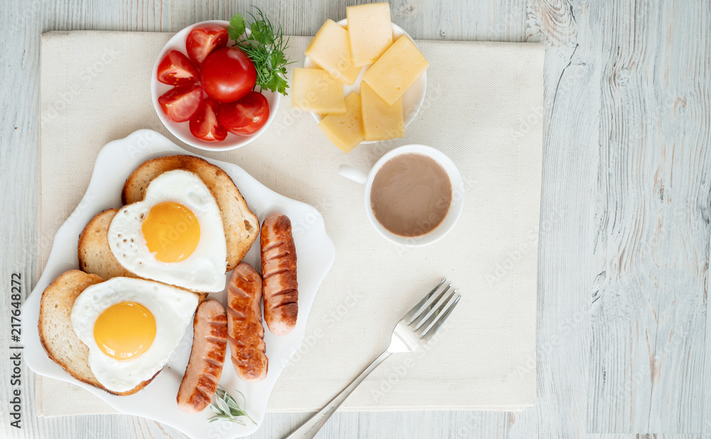 Breakfast with love - fried eggs in the shape of a heart, fried sausages and coffee