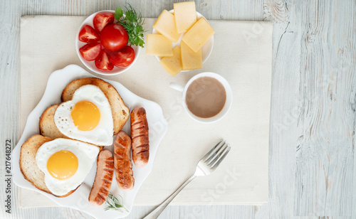 Obraz na płótnie Breakfast with love - fried eggs in the shape of a heart, fried sausages and coffee w salonie