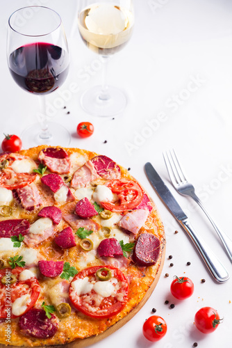 Hot true pepperoni pizza with salami and cheese on white wooden table with decoration. Copy space for your logo.