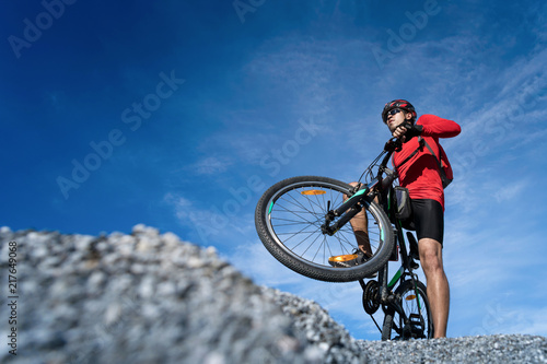 Photography Young man riding mountain bike on the background of mountains at blue sky