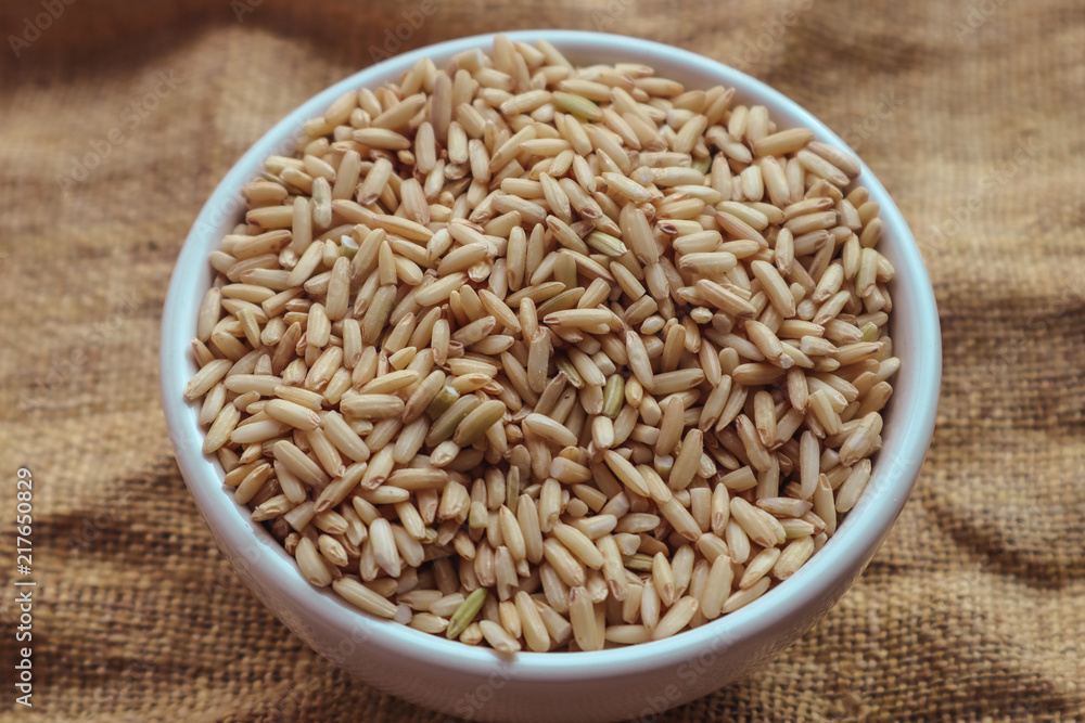 Raw brown rice in a bowl. top view food background Raw brown rice in a bowl. top view food background