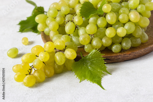Bunch of green grapes. Fruits of autumn on light grey background with copy space, close-up.