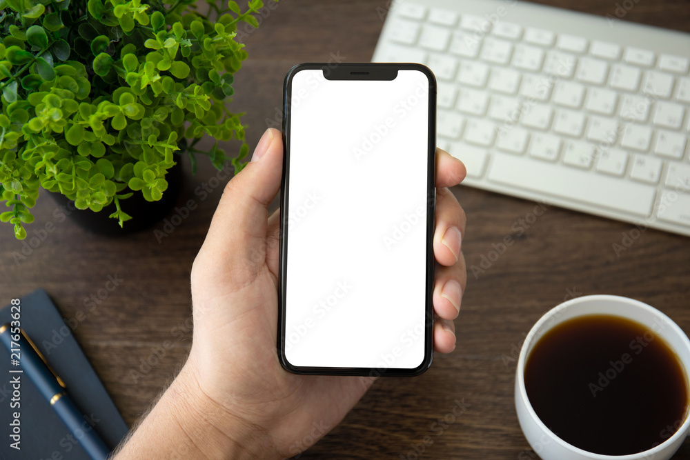 man hand holding phone with isolated screen in office man hand holding phone with isolated screen in office