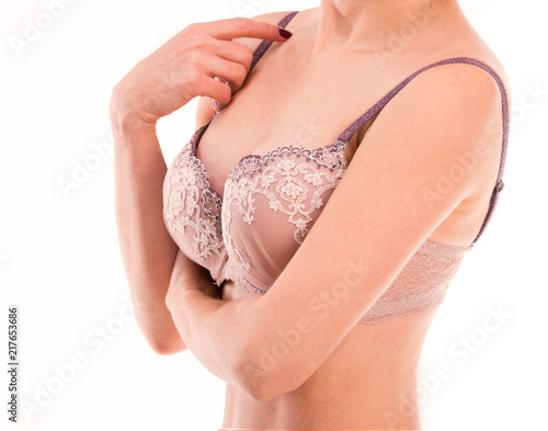 Woman in laced lingerie touching her bra strap, isolated on a white background