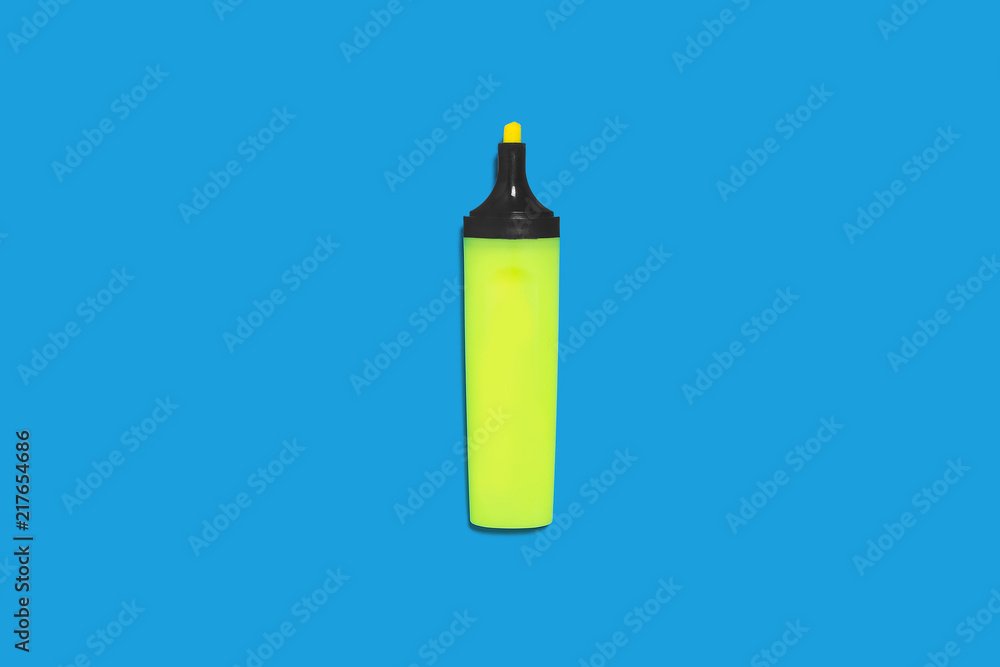 new green bright plastic marker lying on a blue background without a cap. concept of office supplies new green bright plastic marker lying on a blue background without a cap. concept of office supplies