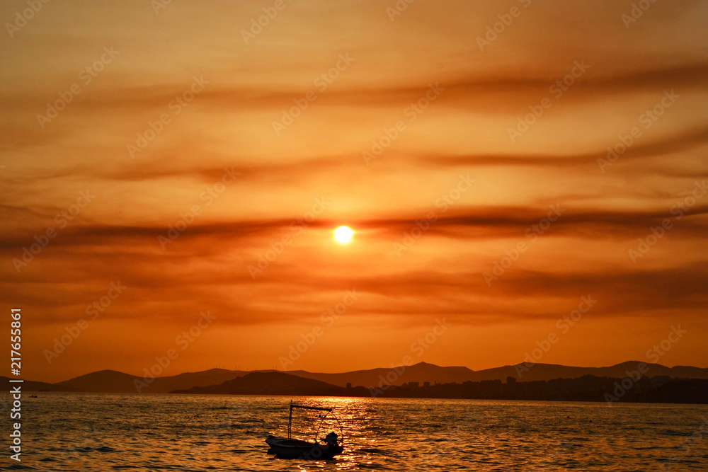 Magical summer sunset scene over tropical sea/ Lonely boat at the sea during golden hour