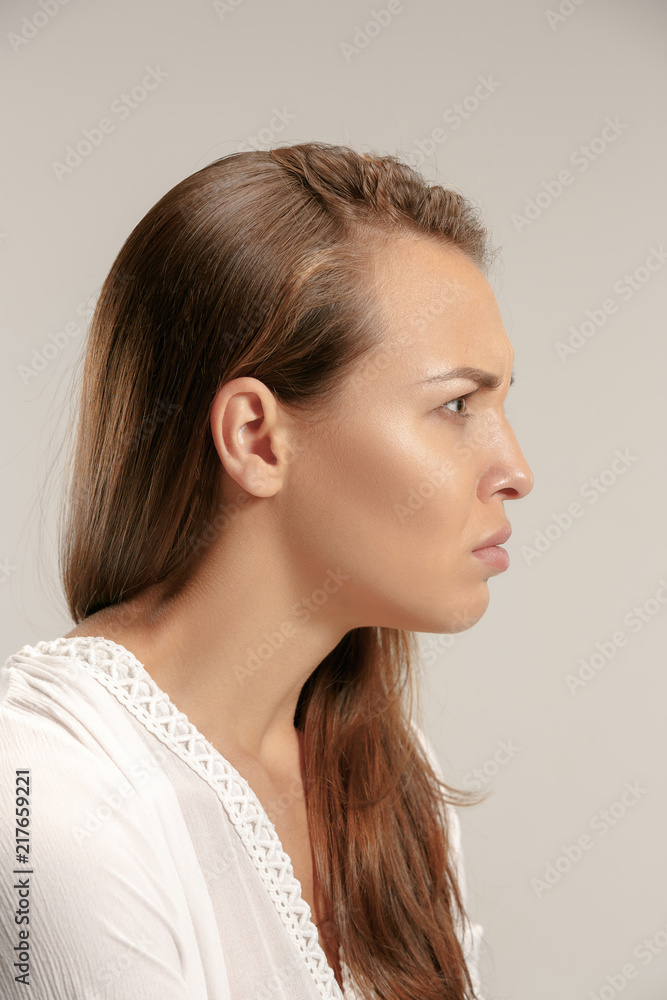 Angry woman looking at camera. Aggressive business woman standing isolated on gray studio background. Female profile portrait. Human emotions, facial expression concept. Angry woman looking at camera. Aggressive business woman standing isolated on gray studio background. Female profile portrait. Human emotions, facial expression concept.