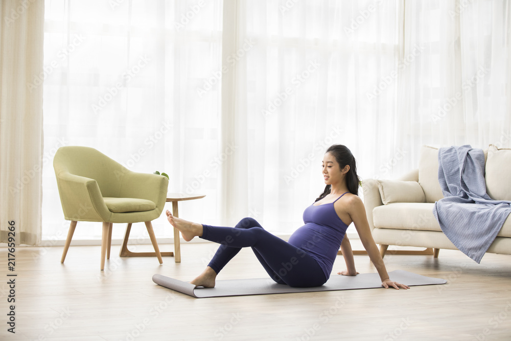 Cheerful pregnant woman practicing yoga at home Cheerful pregnant woman practicing yoga at home