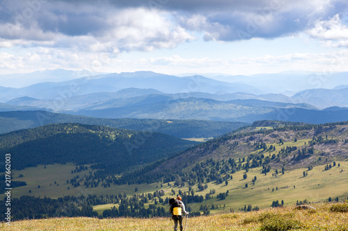 Wallpaper Mural Hiking woman with backpack traveler on top of mountains. Stylish woman hiking, in the background a green forest, field and high mountains.Travel Lifestyle and survival concept rear view. Torontodigital.ca