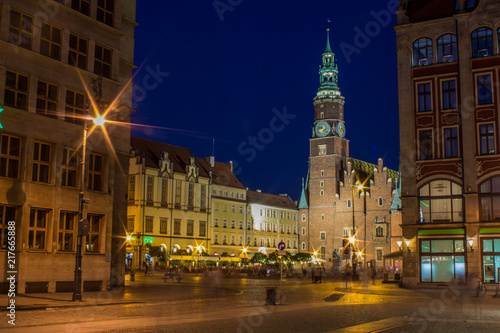 soft focus night long exposure concept of old medieval city scape square view with catholic church illumination and light glares