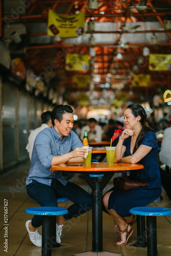 Photography Image of a Chinese Asian young couple enjoying a snack together at a hawker center in Singapore, Asia