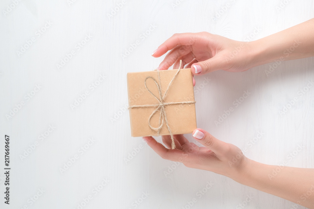 hands of a young girl holding a gift box on a white background hands of a young girl holding a gift box on a white background
