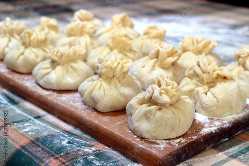Wallpaper Mural Homemade delicious raw manti (turkish ravioli) from dough on a board sprinkled with flour. Preparation of Manti. Torontodigital.ca