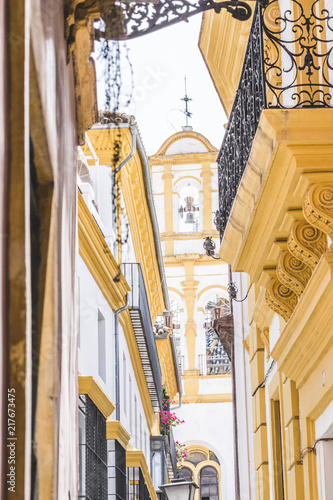 Picturesque Seville street with traditional yellow-white houses