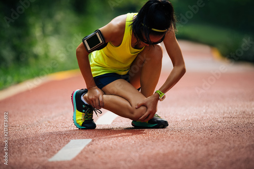 Fototapeta Naklejka Na Ścianę i Meble -  Female runner suffering with pain on sports running knee injury .