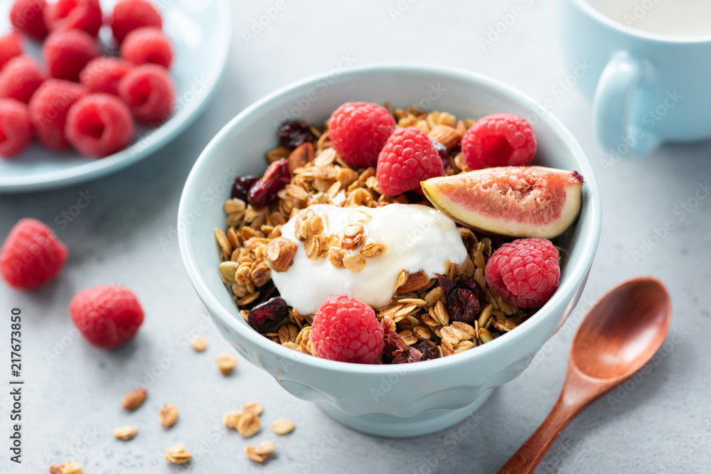Granola bowl with yogurt, figs and raspberries. Healthy breakfast, healthy snack, concept of healthy lifestyle and eating. Closeup view, selective focus. Blue crockery Granola bowl with yogurt, figs and raspberries. Healthy breakfast, healthy snack, concept of healthy lifestyle and eating. Closeup view, selective focus. Blue crockery