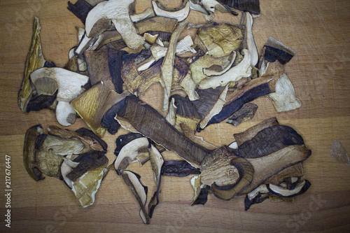 Dried domestic mushrooms collected in the forest. Dried mushrooms prepared for cooking or for seasoning food. Mushrooms cut into slices lying on a wooden plank.